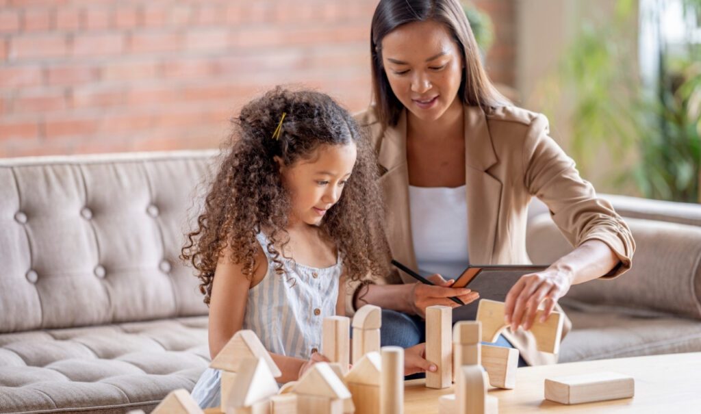 Child and therapist using wooden blocks to talk