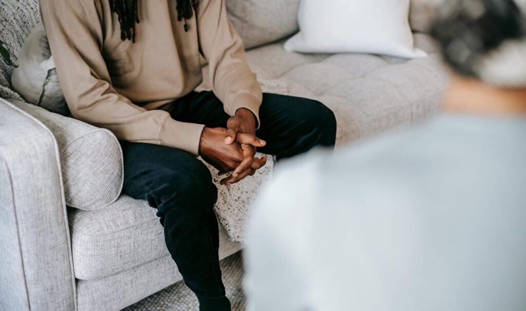 Man on couch talking to a therapist